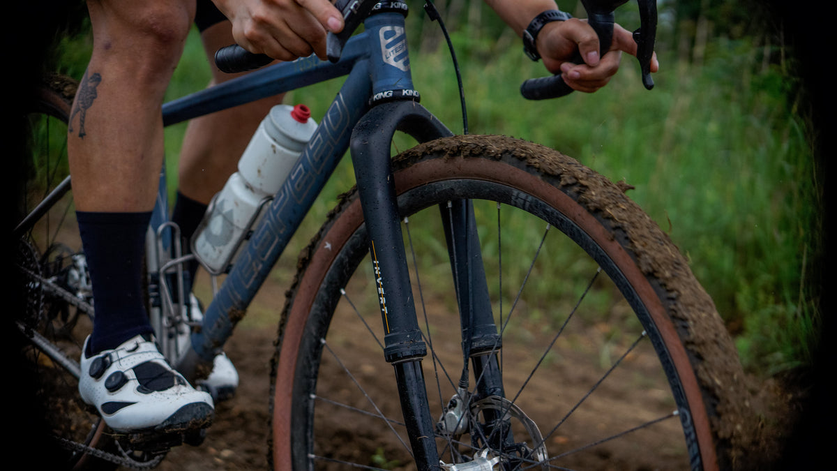 Person riding a bicycle on a dirt path with a blurred background